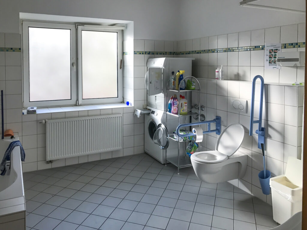 Übergangswohnung barrierefreies Bad: Waschmaschine, Trockner, Toilette, Teil der Badewanne