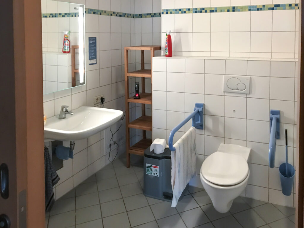 Übergangswohnung barrierefreies Bad: Toilette und Waschbecken, Regal